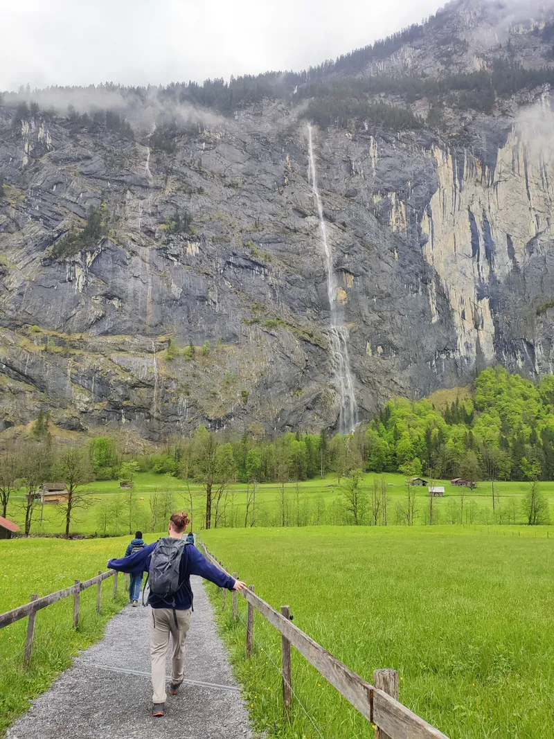 Cascade tombant d’une haute falaise au-dessus d’une prairie