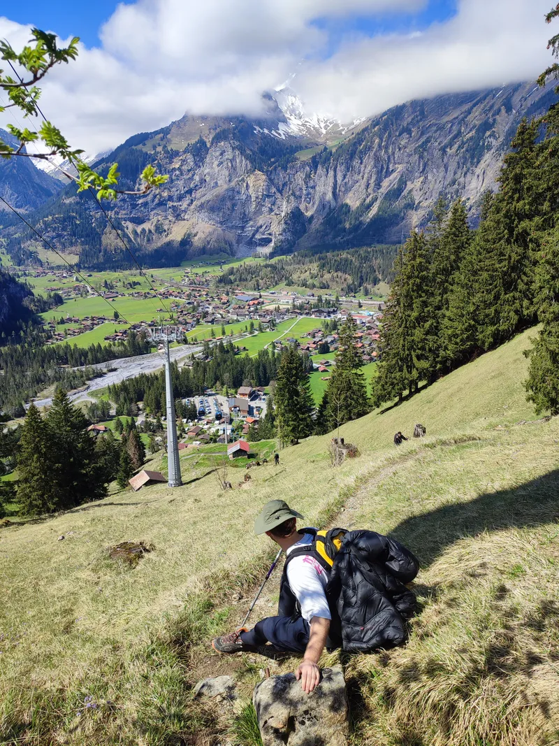 Descente vers un village de fond de vallée, câble de télécabine au-dessus du sentier